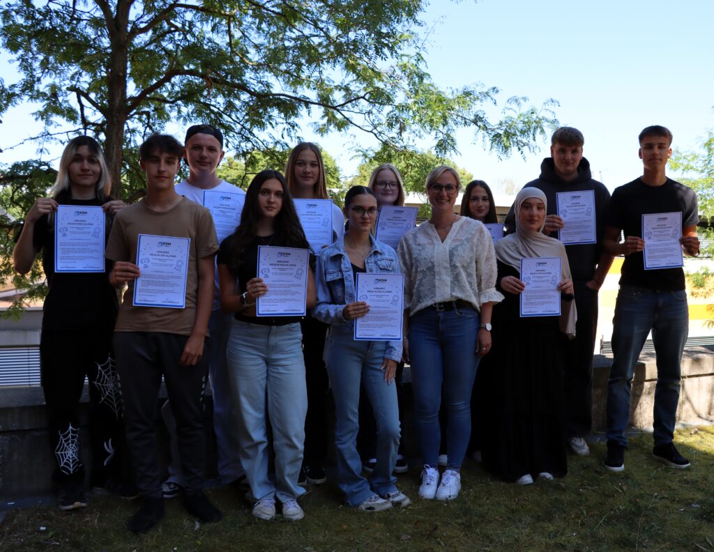 Students from the Business School with their homeroom teacher, Ms. Ruf, and their "Everyday Heroes" certificates